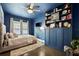 Blue bedroom featuring a large bed, ceiling fan, built-in bookcase, and wood floors at 132 17Th N Ave, St Petersburg, FL 33704