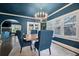 Elegant dining room with a modern chandelier, dark blue walls, and natural light from multiple windows at 132 17Th N Ave, St Petersburg, FL 33704