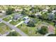 Aerial view of a neighborhood showcasing the property, mature trees, green lawns and the surrounding homes at 13295 Don Loop, Spring Hill, FL 34609