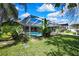 View of the screened-in pool, outdoor bar, and spacious lawn at 13295 Don Loop, Spring Hill, FL 34609