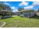Spacious backyard with green grass, outdoor kitchen, and screened-in pool at 13295 Don Loop, Spring Hill, FL 34609