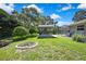 Large backyard with green grass, BBQ area, pool, and firepit at 13295 Don Loop, Spring Hill, FL 34609