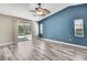 Sunlit bedroom boasts sliding glass doors leading to a pool, complemented by stylish ceiling fan and wood-look floors at 13295 Don Loop, Spring Hill, FL 34609