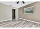 Neutral bedroom with wood-look floors, large window and doorway to another room at 13295 Don Loop, Spring Hill, FL 34609