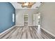 The bedroom features wood-look floors, blue accent wall, and offers views into the bathroom and hallway at 13295 Don Loop, Spring Hill, FL 34609