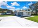 Charming single-story home featuring a covered parking area, lush lawn, and a spacious driveway at 13295 Don Loop, Spring Hill, FL 34609
