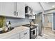 Well-lit kitchen features modern stainless steel appliances, white cabinets, and sleek marble countertops at 13295 Don Loop, Spring Hill, FL 34609