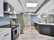 Bright kitchen with stainless appliances, a skylight and a gray backsplash complemented by white cabinets at 13295 Don Loop, Spring Hill, FL 34609
