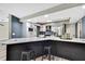 Modern kitchen featuring stainless steel appliances, breakfast bar with white countertop, and dark gray cabinets at 13295 Don Loop, Spring Hill, FL 34609