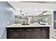 Kitchen island featuring a breakfast bar with sink and modern faucet and dark cabinets at 13295 Don Loop, Spring Hill, FL 34609