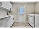 Bright laundry room with modern sink, white cabinets and front-loading washer and dryer at 13295 Don Loop, Spring Hill, FL 34609