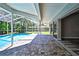 Covered patio with brick pavers overlooks a screened pool in this home's backyard at 13295 Don Loop, Spring Hill, FL 34609