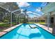Beautiful screened-in pool featuring blue water, chair, and brick pavers at 13295 Don Loop, Spring Hill, FL 34609