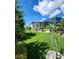 Landscaped backyard with lush greenery, a screened in patio, and tropical foliage at 15301 Chinook Way, Port Charlotte, FL 33981
