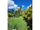 Lush backyard featuring tropical landscaping and manicured lawn and enclosed patio at 15301 Chinook Way, Port Charlotte, FL 33981