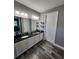 Double sink vanity with granite countertop, wood-look tile floors, and modern lighting at 15301 Chinook Way, Port Charlotte, FL 33981