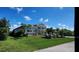 Single story home featuring a landscaped lawn, well-maintained garden and driveway with palm trees at 15301 Chinook Way, Port Charlotte, FL 33981