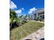 Manicured front yard with lush green grass and tropical landscaping at 15301 Chinook Way, Port Charlotte, FL 33981