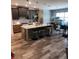 Modern kitchen featuring an island with marble countertop, wooden flooring, and stainless steel appliances at 15301 Chinook Way, Port Charlotte, FL 33981