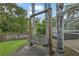 Cozy backyard with a charming wooden swing and lush greenery, perfect for relaxation at 28707 Raleigh Pl, Wesley Chapel, FL 33545