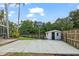 Spacious backyard with a basketball court, shed, and partial fence, providing recreational opportunities at 28707 Raleigh Pl, Wesley Chapel, FL 33545