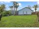 Backyard view with pool enclosure, lush green grass, and home exterior at 28707 Raleigh Pl, Wesley Chapel, FL 33545