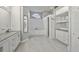 Bright bathroom featuring double vanity, tub, walk-in shower, and built-in storage shelves and cabinets at 28707 Raleigh Pl, Wesley Chapel, FL 33545