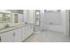 Bright bathroom featuring double vanity, tub, walk-in shower, and built-in storage shelves and cabinets at 28707 Raleigh Pl, Wesley Chapel, FL 33545