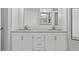 Bright bathroom featuring double vanity with a gray granite countertop and bright white cabinets at 28707 Raleigh Pl, Wesley Chapel, FL 33545