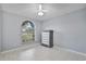 Bright bedroom featuring tile floors, a ceiling fan, and a large window for natural light at 28707 Raleigh Pl, Wesley Chapel, FL 33545