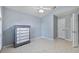 Spacious bedroom with tile floors, white trim, and a 5-drawer dresser at 28707 Raleigh Pl, Wesley Chapel, FL 33545