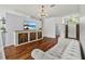 Comfortable living room with hardwood floors, a white sofa, shiplap walls, and an eye-catching light fixture at 28707 Raleigh Pl, Wesley Chapel, FL 33545