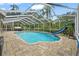 Backyard with a beautiful enclosed pool, complete with a slide and lush greenery at 28707 Raleigh Pl, Wesley Chapel, FL 33545