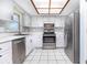 Well-lit kitchen features stainless steel appliances, white cabinetry, and a white tile floor at 4358 Murdock Ave, Sarasota, FL 34231