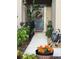 Charming front entrance adorned with a decorative floral wreath and lush landscaping at 10302 Lavender Aster Trl, San Antonio, FL 33576