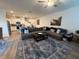 Spacious living room open to the kitchen featuring a large sectional and stylish decor at 10302 Lavender Aster Trl, San Antonio, FL 33576