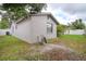 Side view of home showing compact yard with AC unit, hose reel, and partial fencing at 9516 Woodborough Ct, Tampa, FL 33615