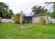 Spacious backyard featuring a patio, lush lawn, and mature landscaping, ideal for outdoor entertaining at 9516 Woodborough Ct, Tampa, FL 33615