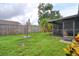 View of a well-maintained backyard, partially fenced with green grass and lush tropical foliage at 9516 Woodborough Ct, Tampa, FL 33615