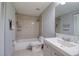 This bathroom features a shower and tub combo, modern vanity and marble effect tile walls at 9516 Woodborough Ct, Tampa, FL 33615