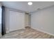 Bedroom featuring wood-look floors, gray walls, and closet with standard bi-fold doors at 9516 Woodborough Ct, Tampa, FL 33615