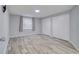 Spacious bedroom with gray laminate floors and natural light at 9516 Woodborough Ct, Tampa, FL 33615