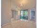 Open dining room with tile flooring, contemporary chandelier, and access to a screened patio through sliding glass doors at 9516 Woodborough Ct, Tampa, FL 33615