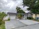 Charming single-story home featuring a gray exterior, well-maintained lawn, mature landscaping, and a two car garage at 9516 Woodborough Ct, Tampa, FL 33615