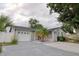Charming single-story home featuring a gray exterior, well-maintained lawn, mature landscaping, and a two car garage at 9516 Woodborough Ct, Tampa, FL 33615