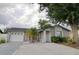 Charming single-story home featuring a gray exterior, well-maintained lawn, mature landscaping, and a two car garage at 9516 Woodborough Ct, Tampa, FL 33615