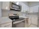 Kitchen features stainless steel appliances and white cabinetry at 9516 Woodborough Ct, Tampa, FL 33615