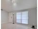 Bright living room featuring tile flooring, neutral gray walls, track lighting, and a large window with modern blinds at 9516 Woodborough Ct, Tampa, FL 33615
