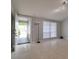 Bright living room featuring tile flooring, neutral gray walls, track lighting, and a front door view at 9516 Woodborough Ct, Tampa, FL 33615