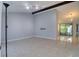 Spacious living room with a neutral color palette, tile flooring, modern lighting, and sliding glass doors to the outdoor space at 9516 Woodborough Ct, Tampa, FL 33615